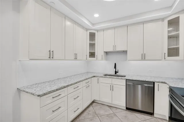 a kitchen with granite countertop white cabinets and white appliances