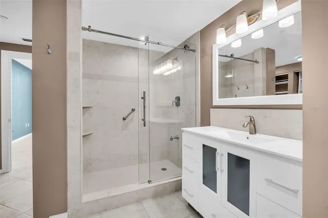 a bathroom with a shower sink vanity and mirror