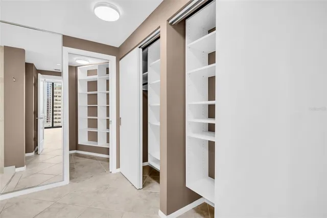 an empty room with windows and ceiling fan