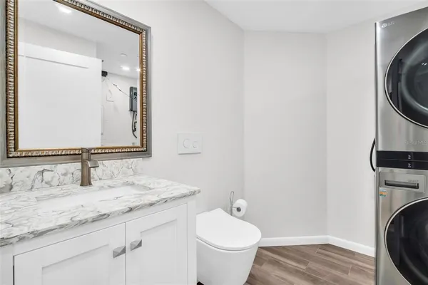 a bathroom with a granite countertop sink a toilet and a vanity