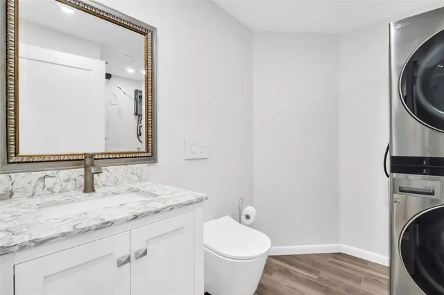 a bathroom with a granite countertop sink a toilet and a vanity