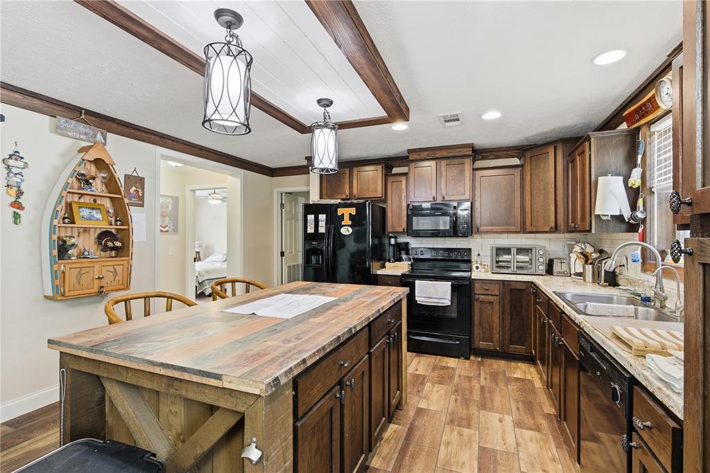 7970 Southwest 14th Place Bell, FL 32619 - Photo 22 of 45 a kitchen with stainless steel appliances kitchen island granite countertop a sink and cabinets