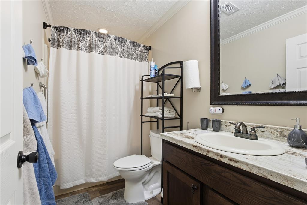 7970 Southwest 14th Place Bell, FL 32619 - Photo 30 of 45 a bathroom with a granite countertop sink toilet and a mirror