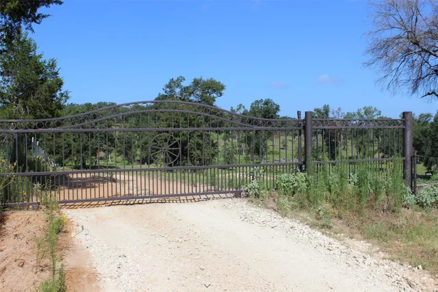a view of a fence and a trees in the background