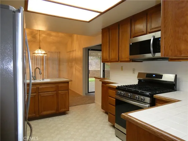 a kitchen with stainless steel appliances a stove a microwave and a sink