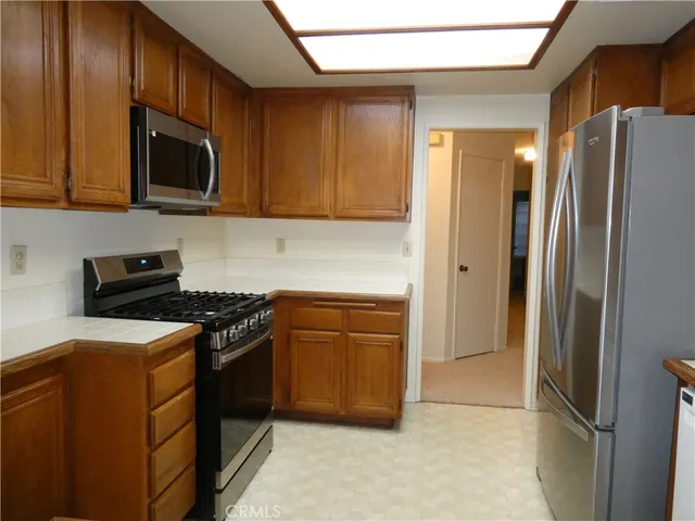 a kitchen with stainless steel appliances granite countertop a refrigerator stove and microwave