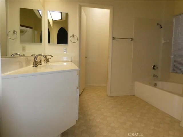 a bathroom with a granite countertop sink a mirror and a bathtub