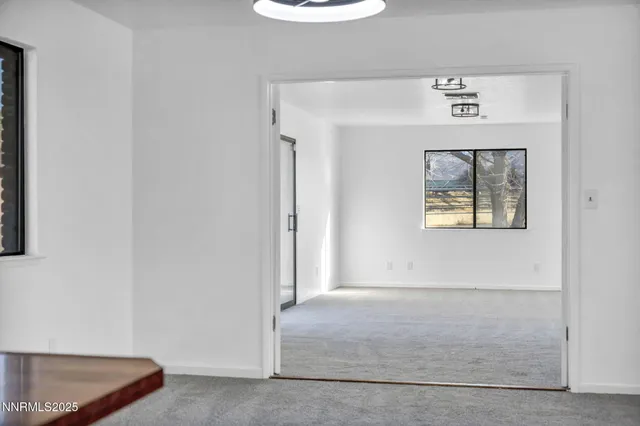 a view of an empty room with a fireplace and a window