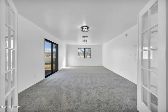 an empty room with a ceiling fan and window