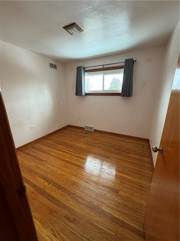 113 Greenhill Drive Butler, PA 16001 - Photo 14 of 19 a view of an empty room with wooden floor and a window