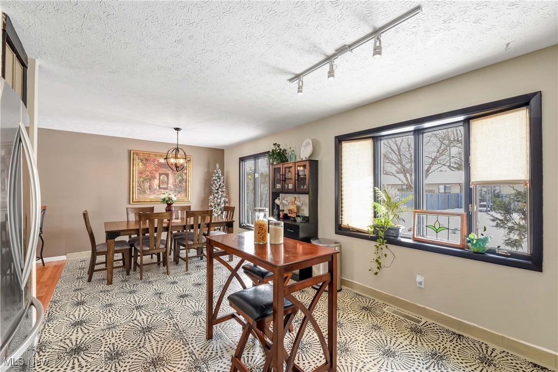 10778 Gate Post Road Strongsville, OH 44149 - Photo 13 of 40 Dining space with a textured ceiling, track lighting, and an inviting chandelier
