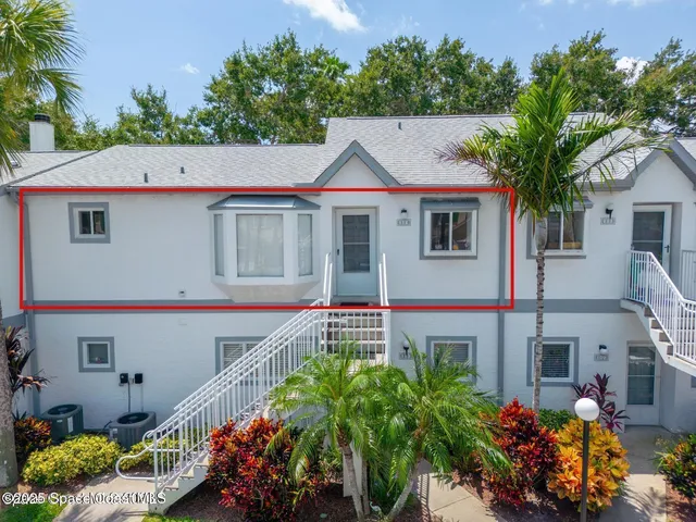 a view of a house with a yard and potted plants