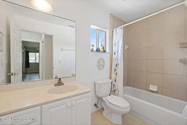 a front view of a house with a yard and potted plants