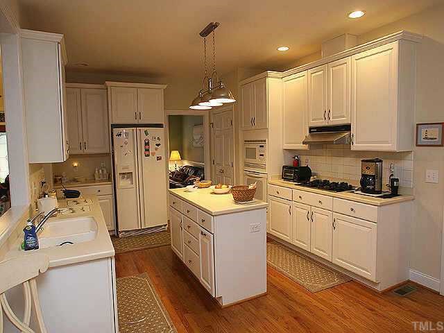 120 Challenge Raleigh, NC 27603 - Photo 4 of 9 a kitchen with a refrigerator a stove and wooden cabinets
