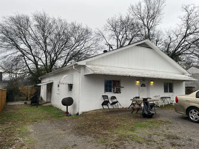 a front view of a building with trees and retail shops