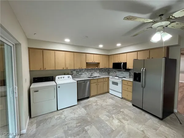 a kitchen with a refrigerator and white cabinets