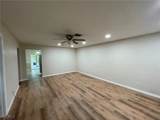 a view of empty room with wooden floor