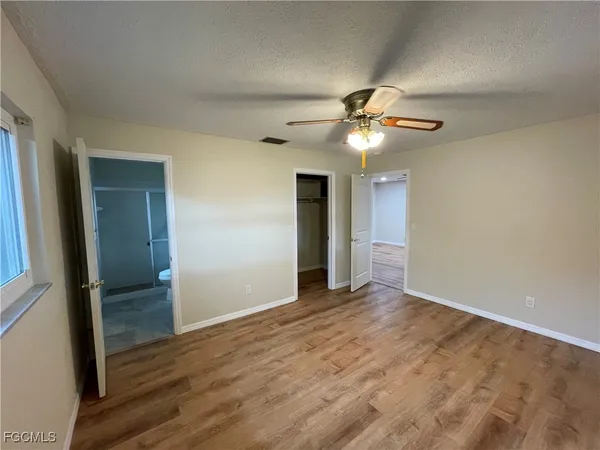 a view of an empty room with closet and a chandelier fan