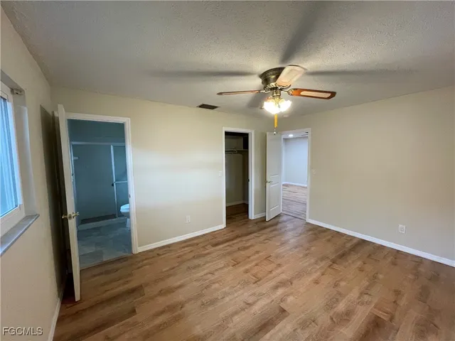 a view of an empty room with closet and a chandelier fan