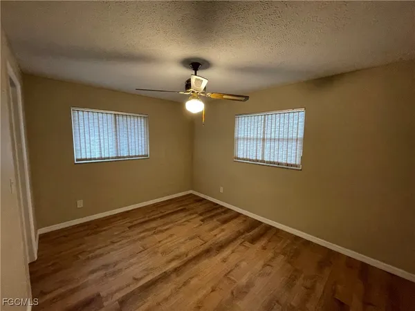 a view of a room with wooden floor and chandelier fan
