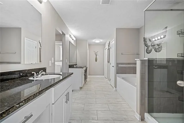 a large bathroom with double vanity and a shower