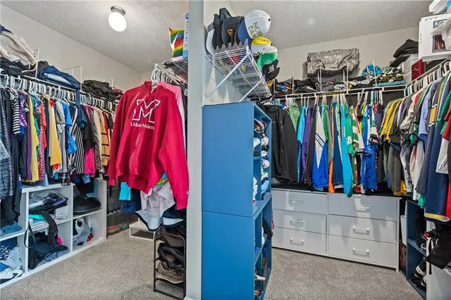 a view of walk in closet with clothes