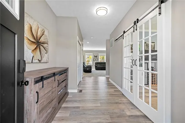 a view of a hallway with wooden floor and staircase