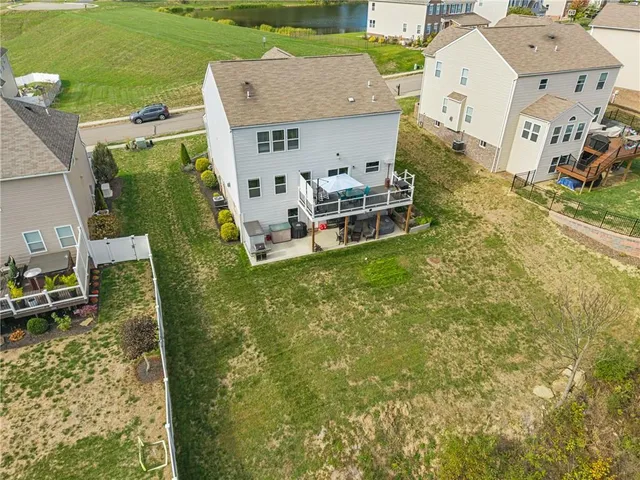 an aerial view of a house with swimming pool and large trees