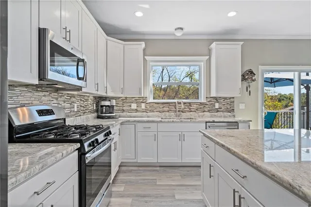 a kitchen with cabinets appliances a sink and a counter top space