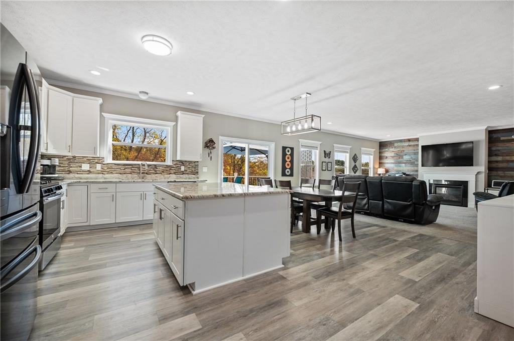 43 Trotter Lane Clinton, PA 15026 - Photo 8 of 34 a kitchen with stainless steel appliances granite countertop a stove top oven a sink dishwasher a dining table and chairs with wooden floor