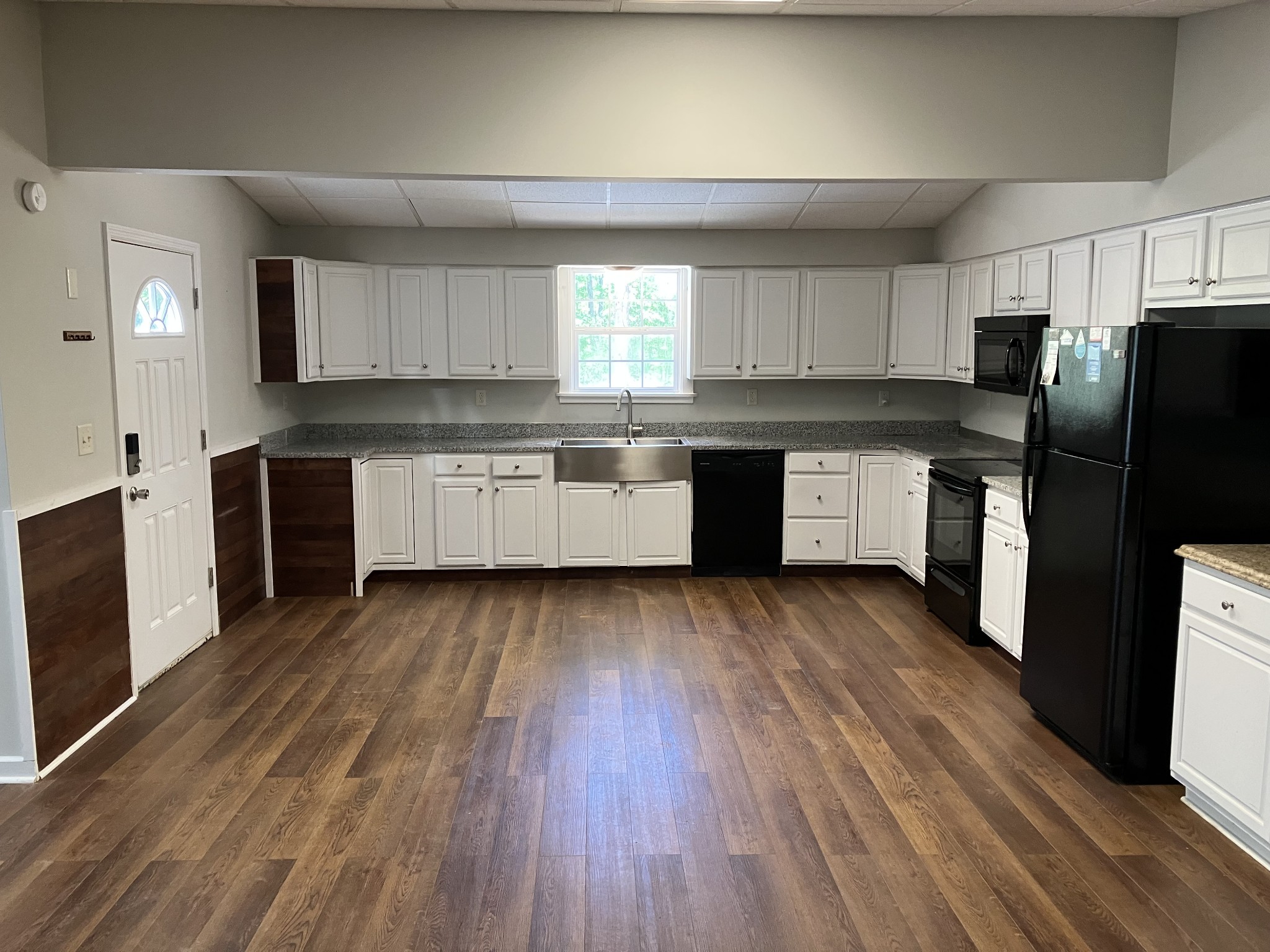 255 S Road Cottontown, TN 37048 - Photo 10 of 35 a kitchen with granite countertop wooden floors a stove and white stainless steel appliances