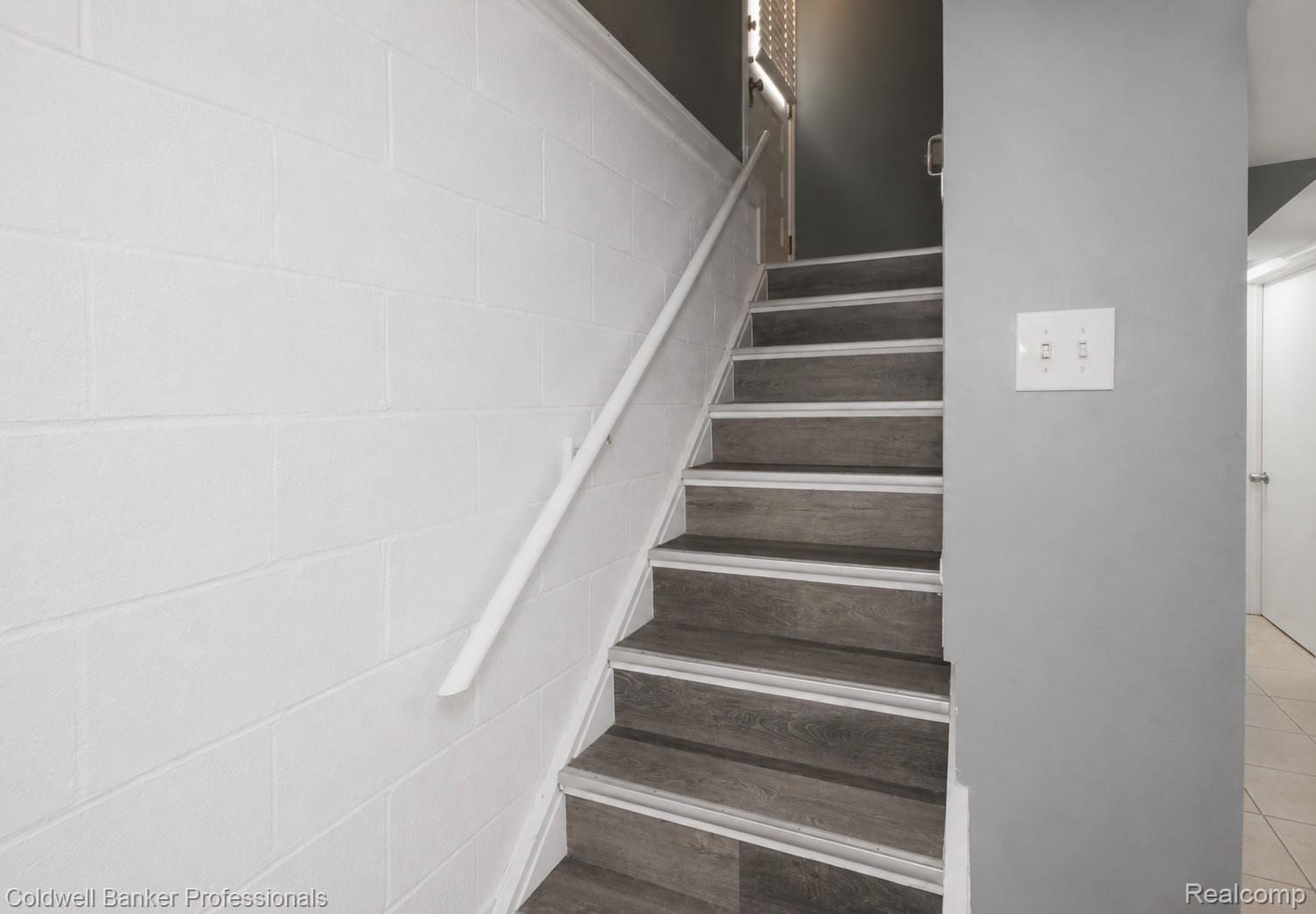 1168 Vernier Road Grosse Pointe, MI 48236 - Photo 27 of 37 Staircase with wood-finish treads, white risers, and a white handrail