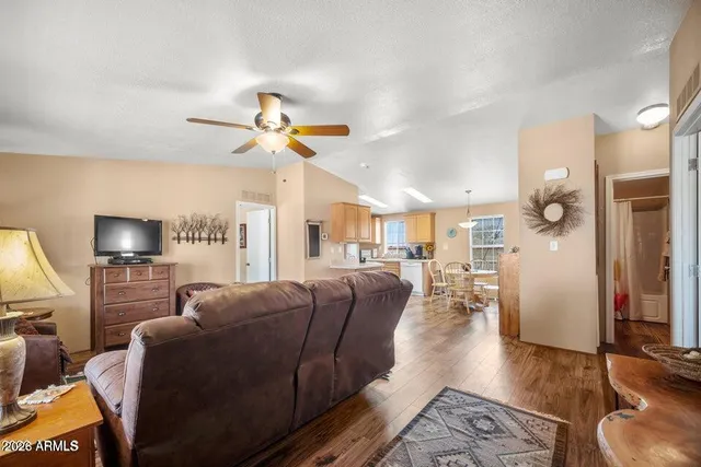 a living room with furniture a ceiling fan and a window