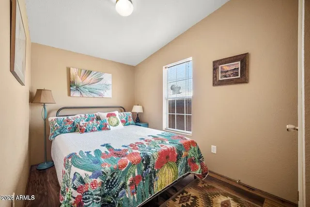 a bedroom with a bed and a painting on the wall