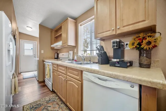 a kitchen with stainless steel appliances granite countertop a sink a refrigerator and a wooden cabinets