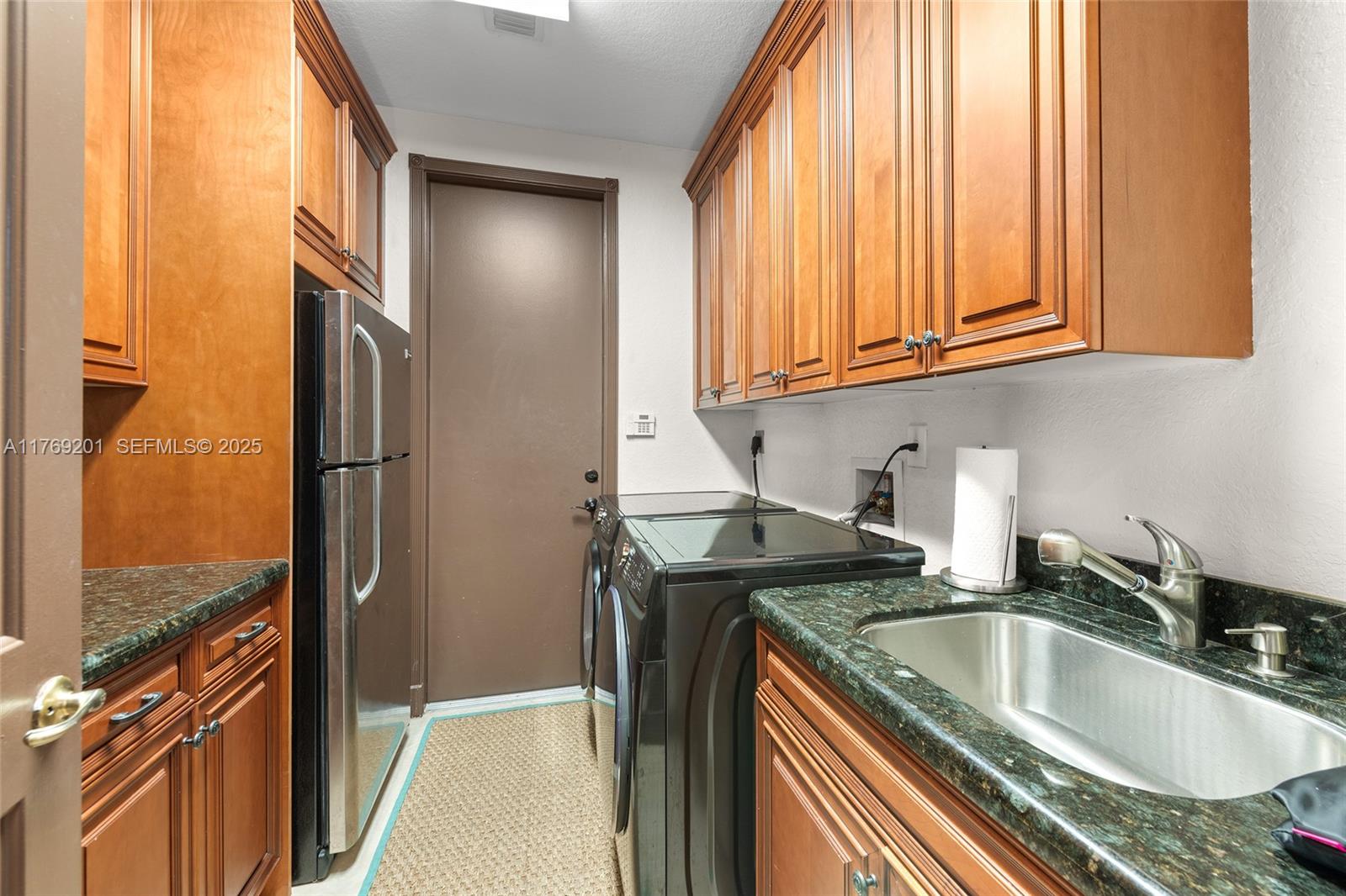 15045 Southwest 37th Street Davie, FL 33331 - Photo 34 of 57 a kitchen with granite countertop a sink a refrigerator and washer