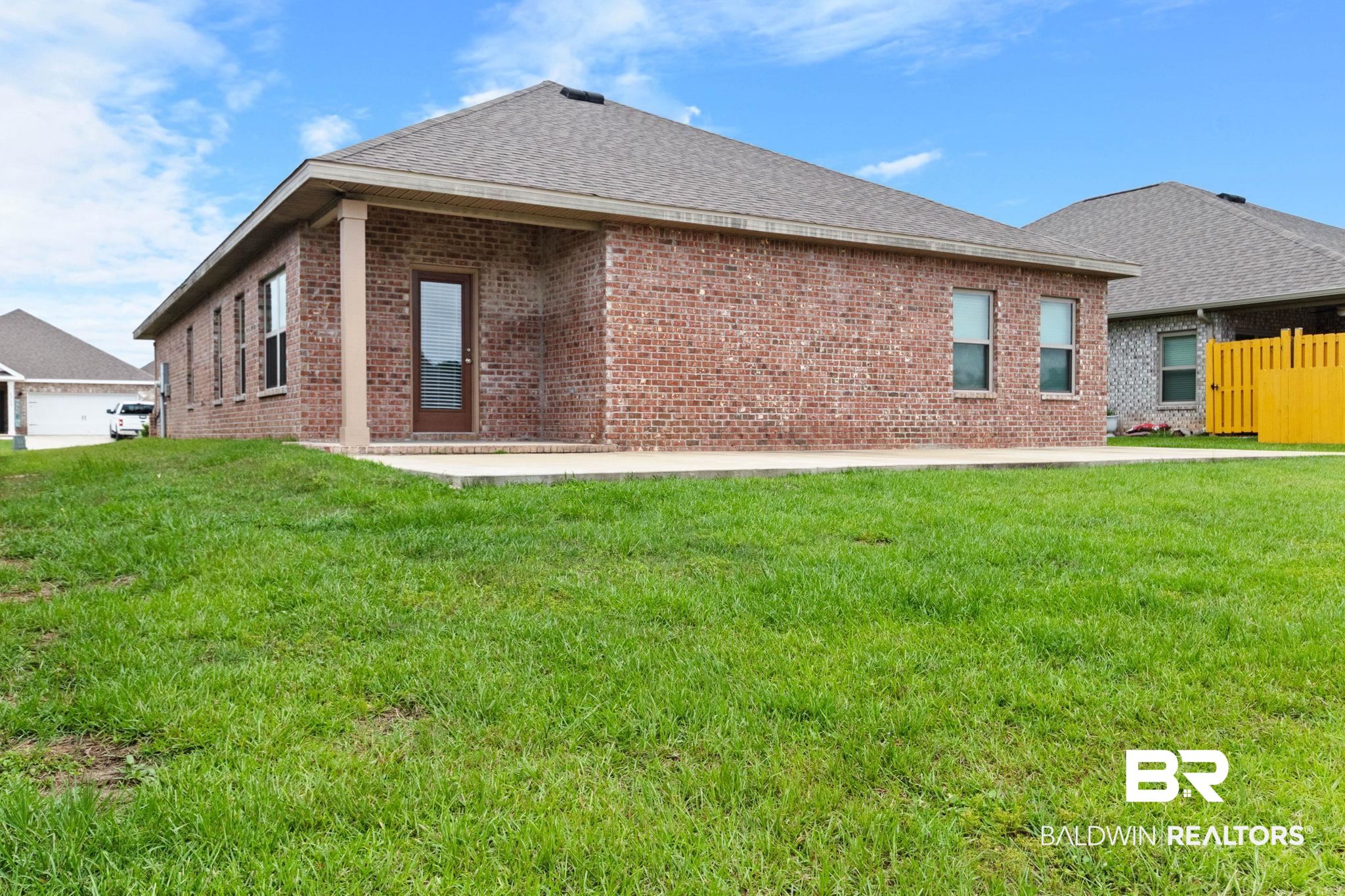 1710 Grouse Street Foley, AL 36535 - Photo 63 of 76 Brick exterior home featuring a covered patio, concrete slab, and multiple windows