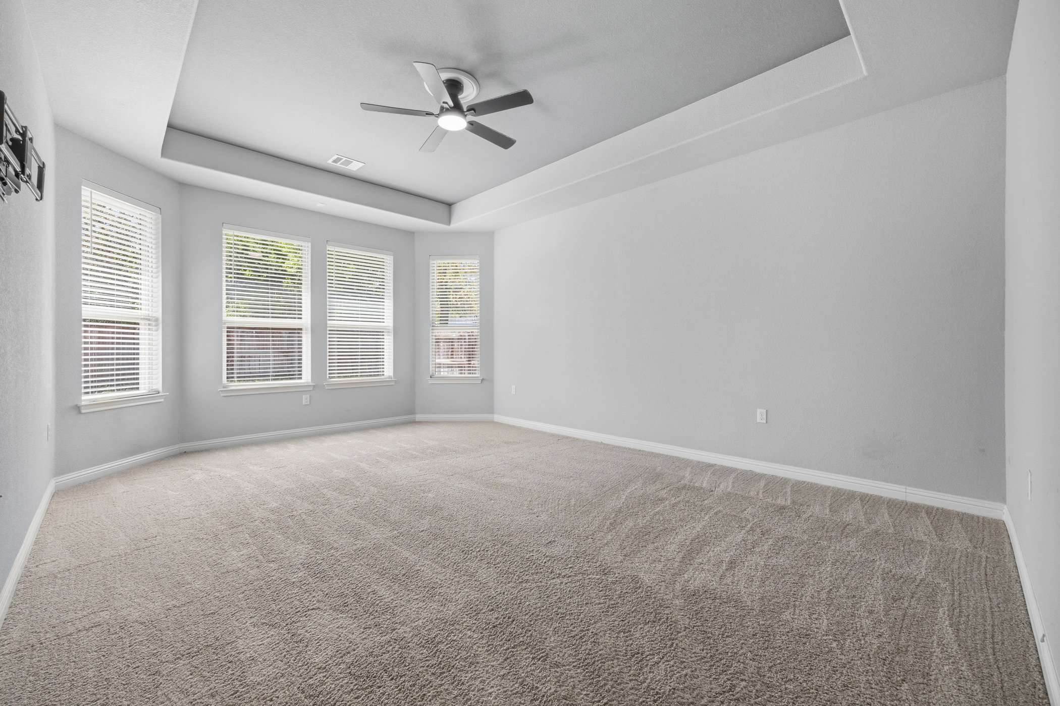 2209 Littleleaf Lane Leander, TX 78641 - Photo 13 of 27 Empty room with a tray ceiling, a ceiling fan, light colored carpet, and healthy amount of natural light