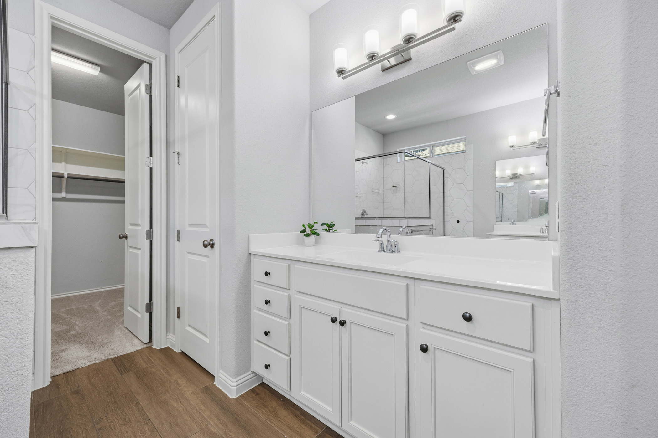 2209 Littleleaf Lane Leander, TX 78641 - Photo 16 of 27 Full bathroom featuring a shower stall, vanity, dark wood-style flooring, and a walk in closet