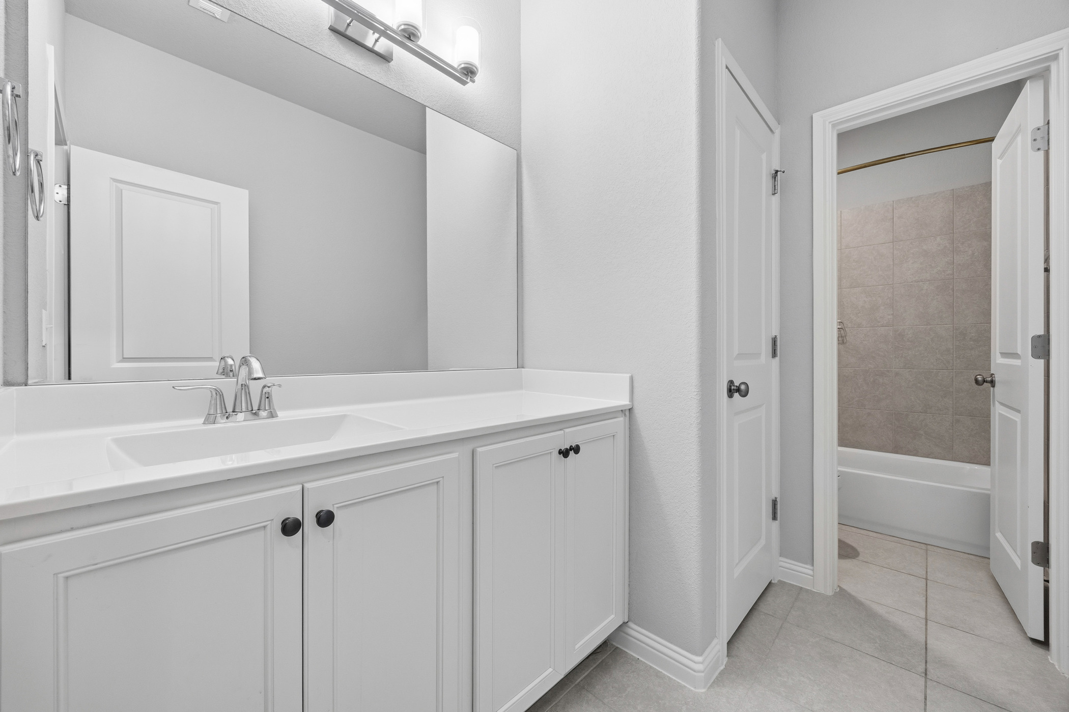 2209 Littleleaf Lane Leander, TX 78641 - Photo 22 of 27 Bathroom with vanity, light tile patterned floors, and shower combination