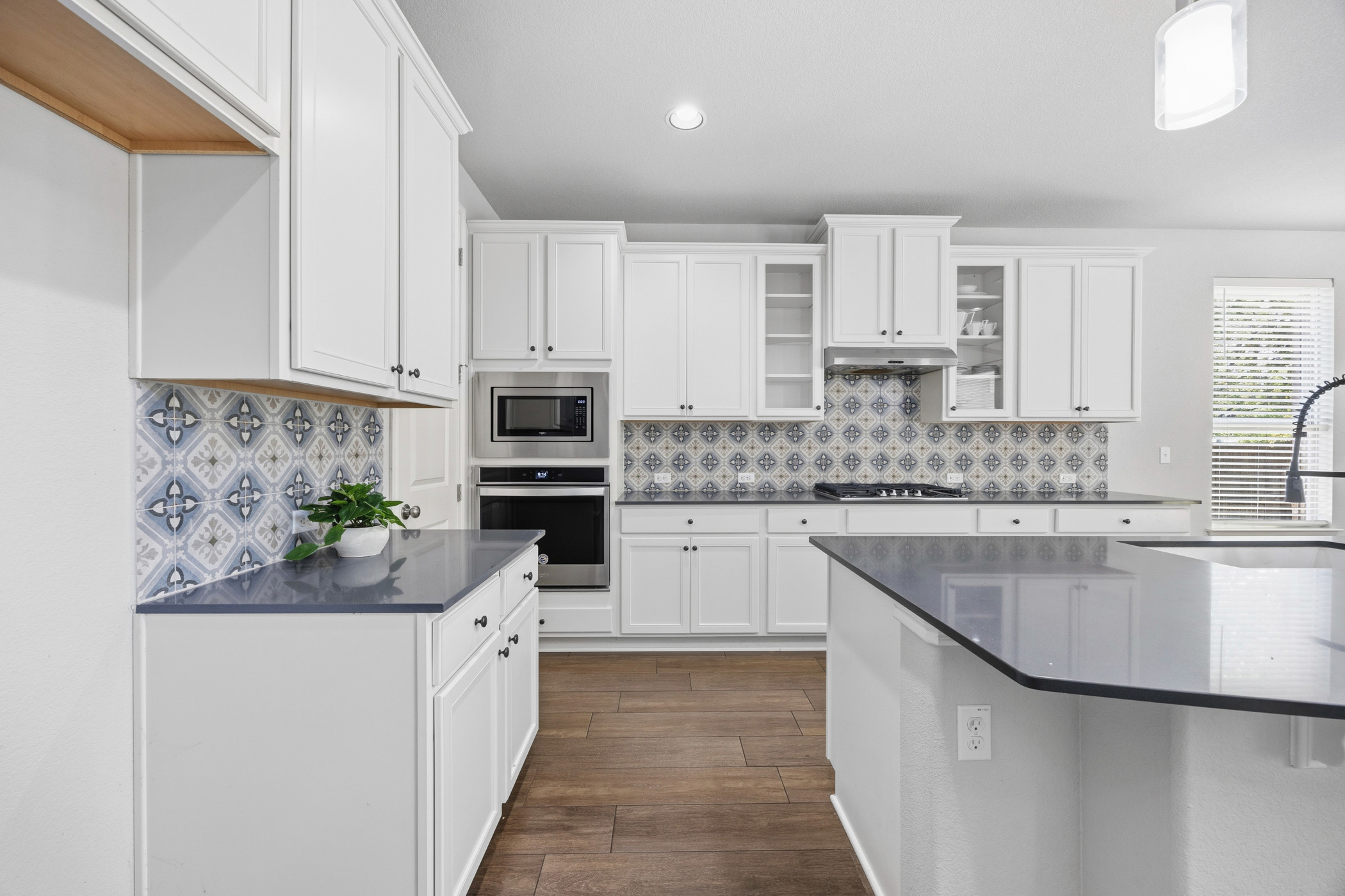 2209 Littleleaf Lane Leander, TX 78641 - Photo 4 of 27 Kitchen with white cabinetry, stainless steel appliances, glass insert cabinets, dark wood-style flooring, and recessed lighting