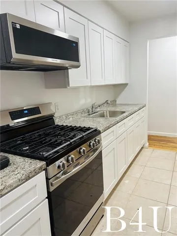 a kitchen with stainless steel appliances granite countertop a stove and a microwave