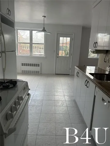 a kitchen with granite countertop a stove a sink and a microwave