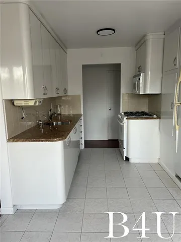 a kitchen with a sink a stove and a refrigerator