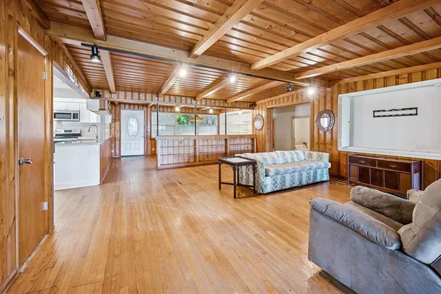 a living room with stainless steel appliances granite countertop lots of wooden furniture