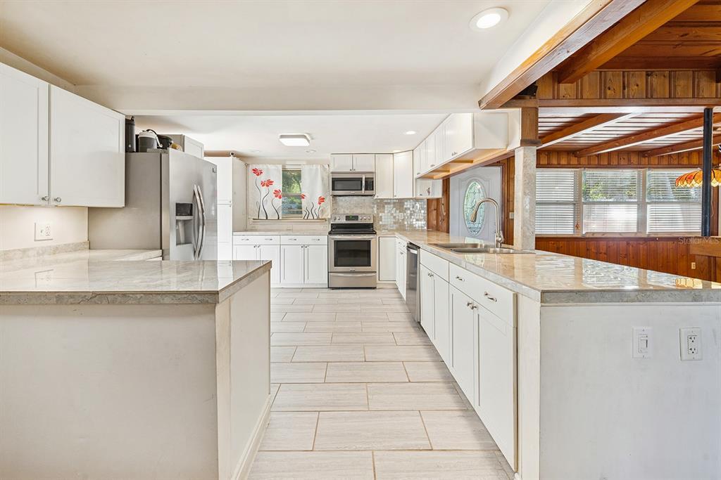 6306 Baker Road Keystone Heights, FL 32656 - Photo 37 of 53 a large kitchen with stainless steel appliances granite countertop a stove and a sink