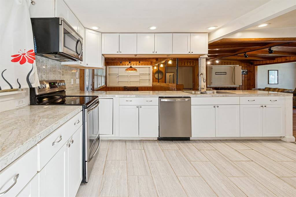6306 Baker Road Keystone Heights, FL 32656 - Photo 38 of 53 a kitchen with stainless steel appliances granite countertop a stove sink and cabinets