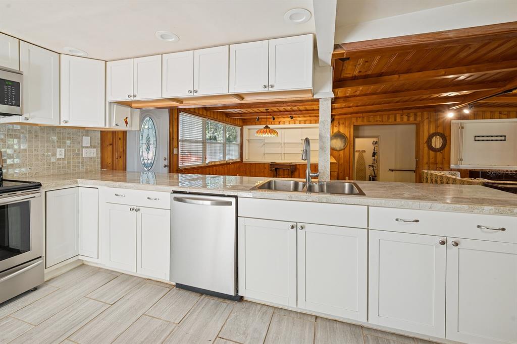 6306 Baker Road Keystone Heights, FL 32656 - Photo 39 of 53 a kitchen with granite countertop white cabinets and white appliances