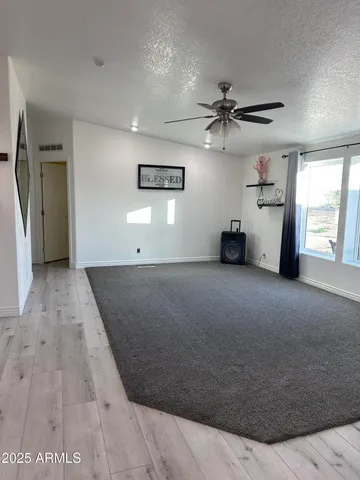 a view of a livingroom with a ceiling fan and window