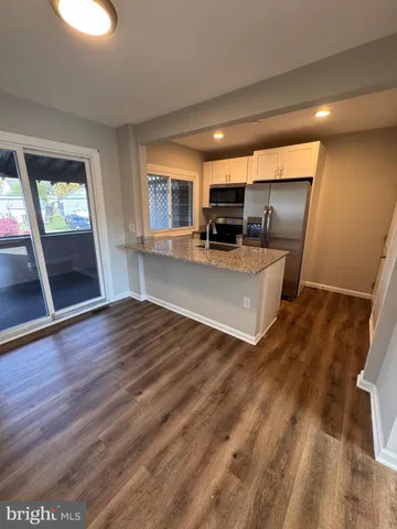 a view of a kitchen with furniture and wooden floor